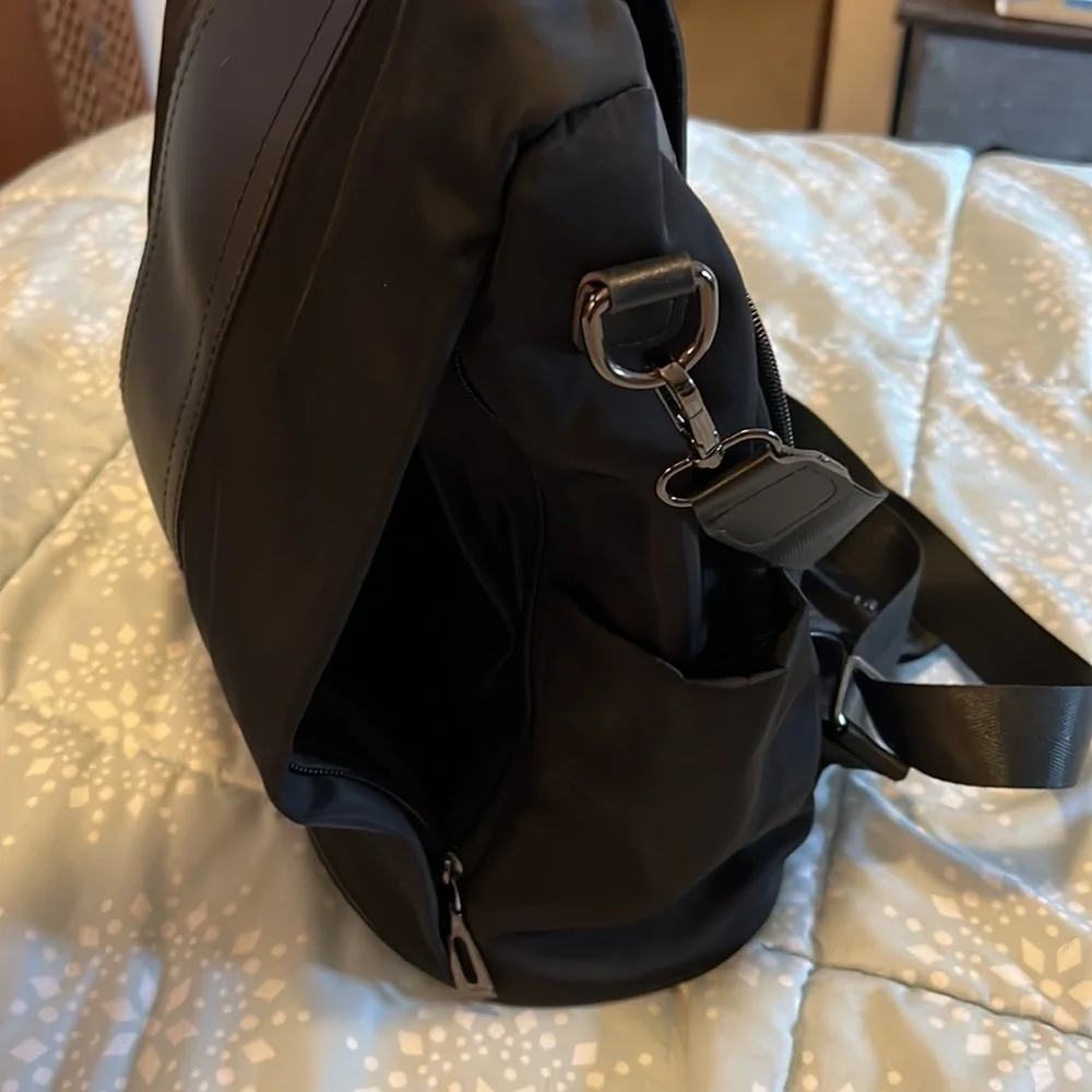 Black backpack, with strap and handle.